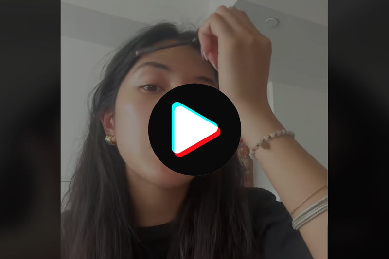 Video frame of a woman applying make-up